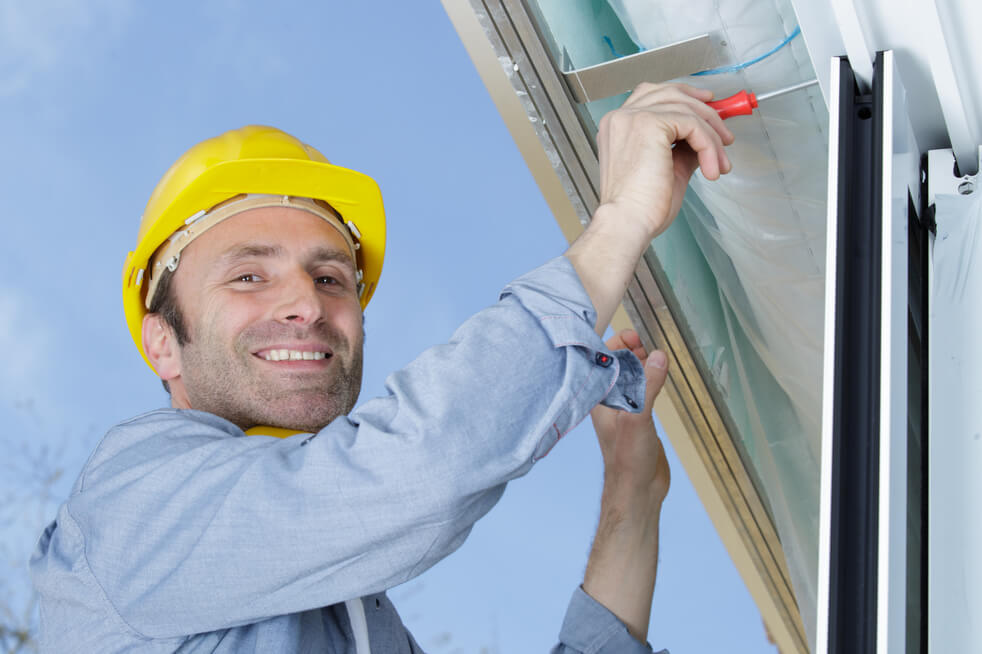 Man installing rain gutters on home